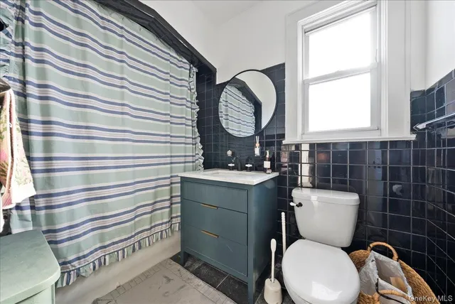 a bathroom with a toilet a sink and a mirror