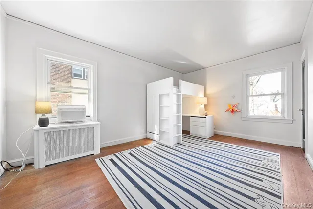 an empty room with windows and wooden floor