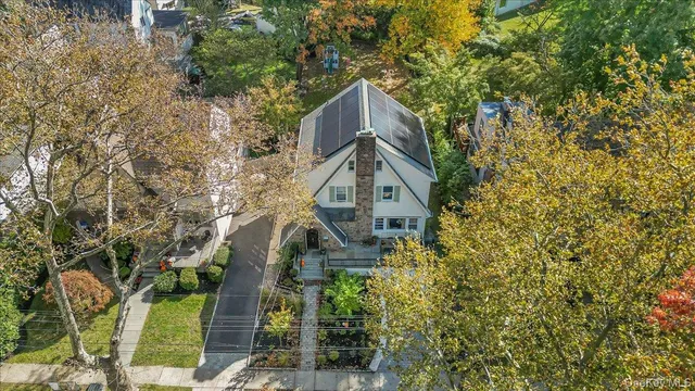 a front view of a house with a tree