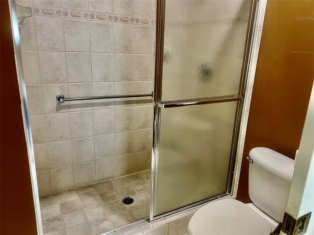 9539 Weldon Circle, Unit F406 Tamarac, FL 33321 - Photo 12 of 22 a bathroom with a toilet and a shower