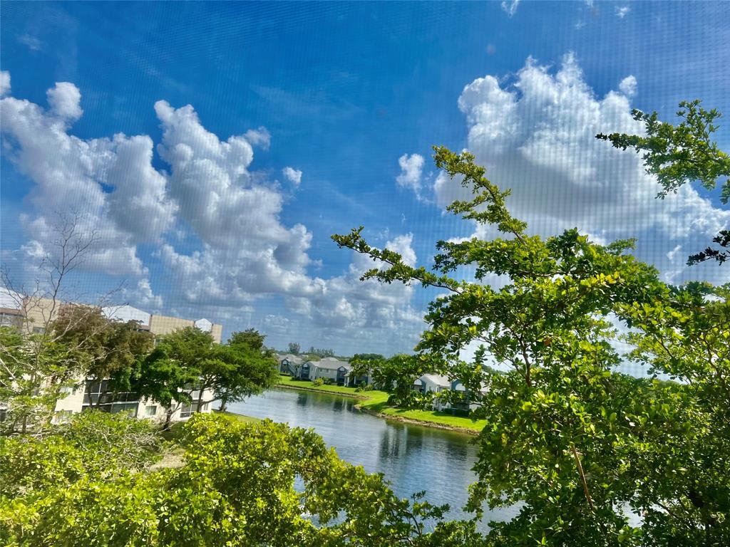 9539 Weldon Circle, Unit F406 Tamarac, FL 33321 - Photo 17 of 22 a view of a lake with a yard
