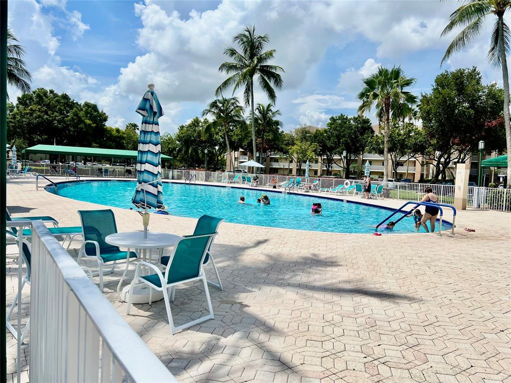 9539 Weldon Circle, Unit F406 Tamarac, FL 33321 - Photo 19 of 22 a view of a swimming pool with a lounge chair