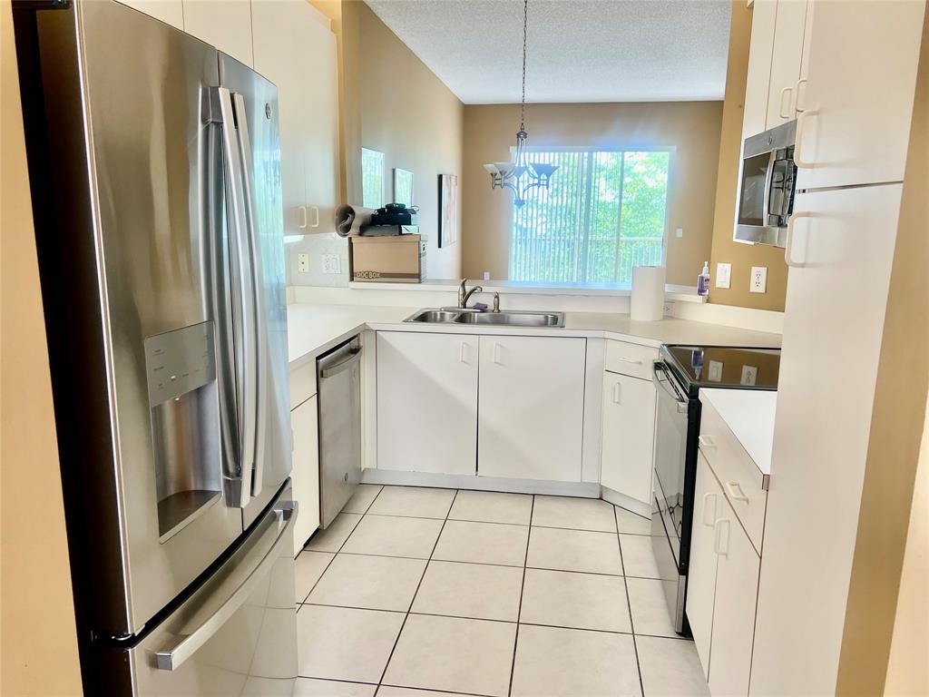 9539 Weldon Circle, Unit F406 Tamarac, FL 33321 - Photo 2 of 22 a kitchen with stainless steel appliances a refrigerator sink and cabinets