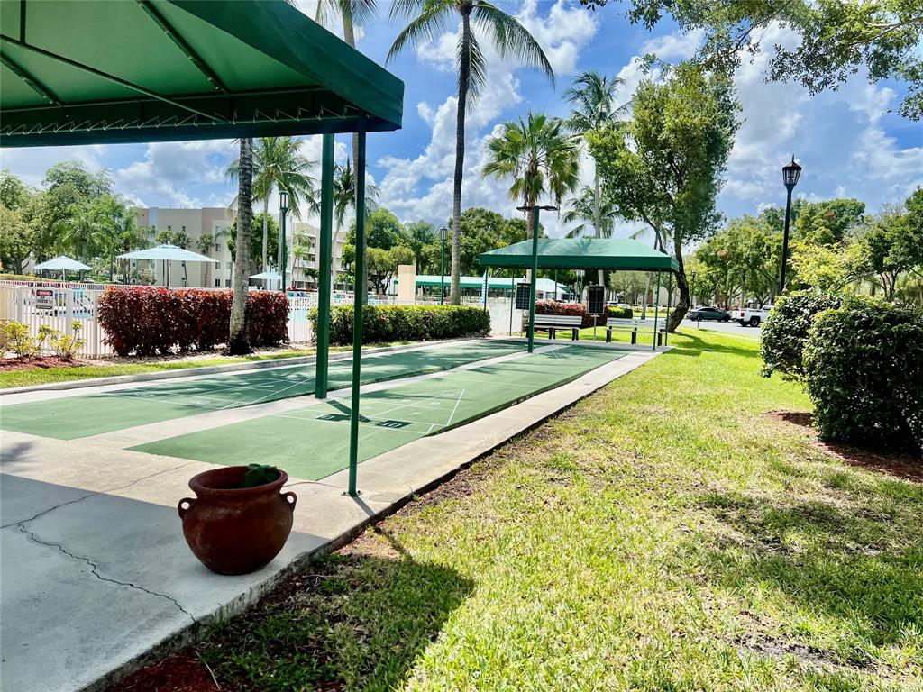 9539 Weldon Circle, Unit F406 Tamarac, FL 33321 - Photo 21 of 22 a view of a garden with an outdoor seating
