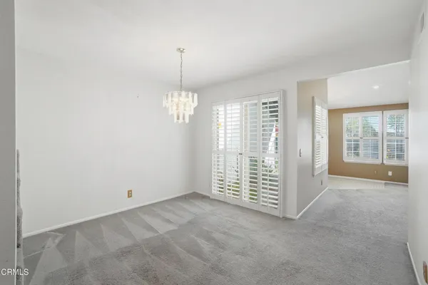 an empty room with windows & cabinet