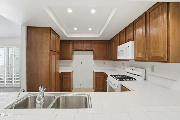 a kitchen that has a sink a stove and a refrigerator
