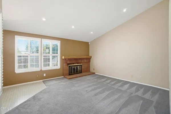 a view of an empty room with a fireplace and a window