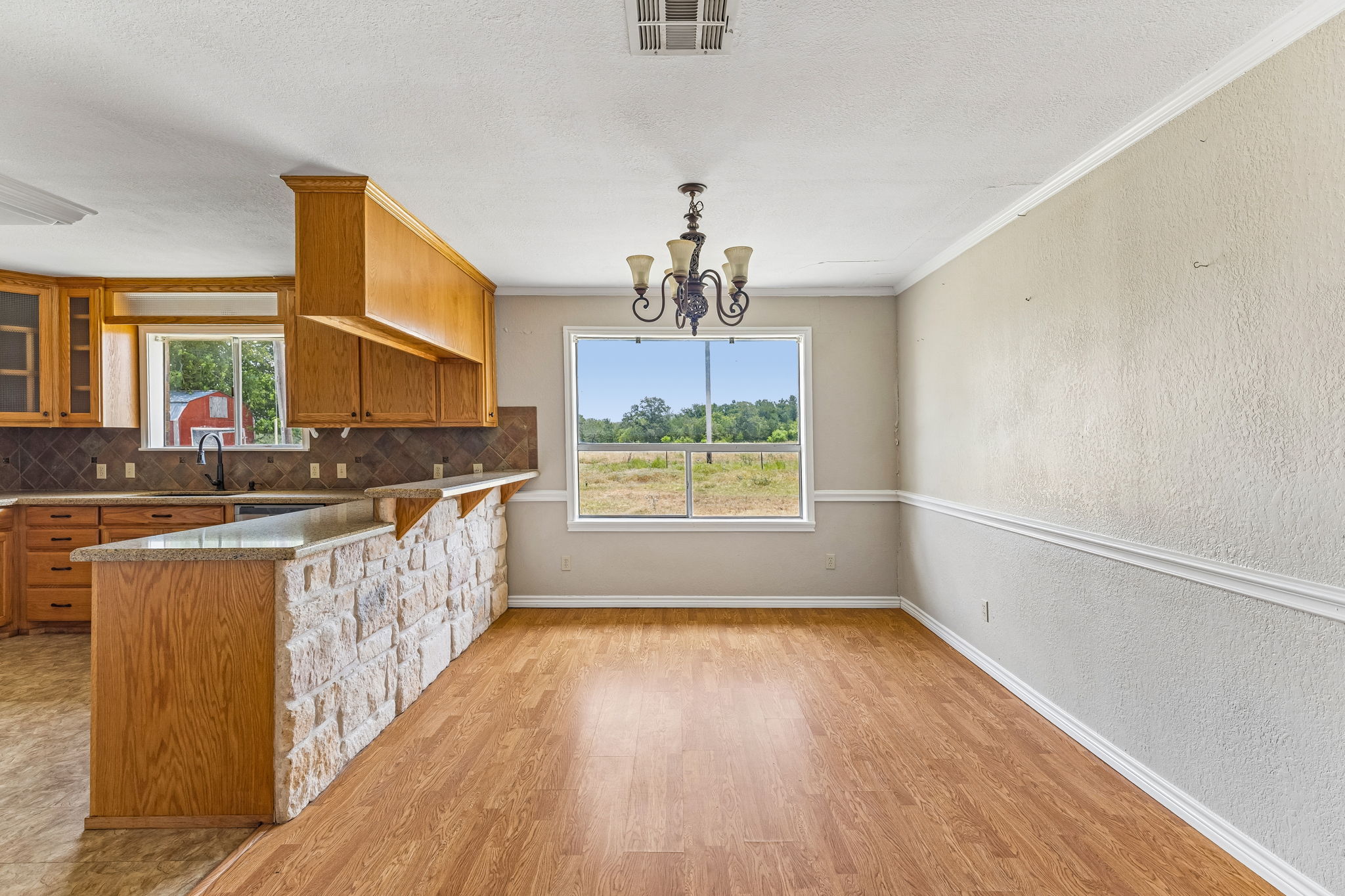 9765 A State Park Road Lockhart, TX 78644 - Photo 6 of 30 A rustic stone breakfast bar connects to a dining area with a country view.