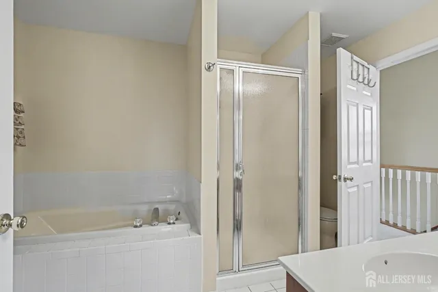 a bathroom with a tub a sink and a large mirror