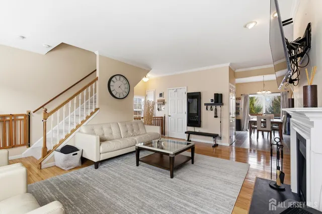 a living room with furniture a wooden floor and next to a window