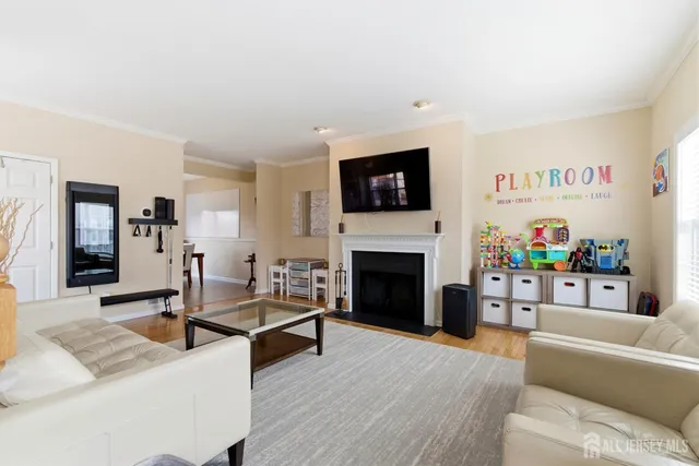 a living room with furniture a flat screen tv and a fireplace