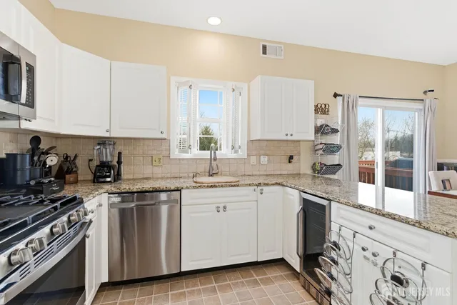 a kitchen with granite countertop cabinets stainless steel appliances and a sink