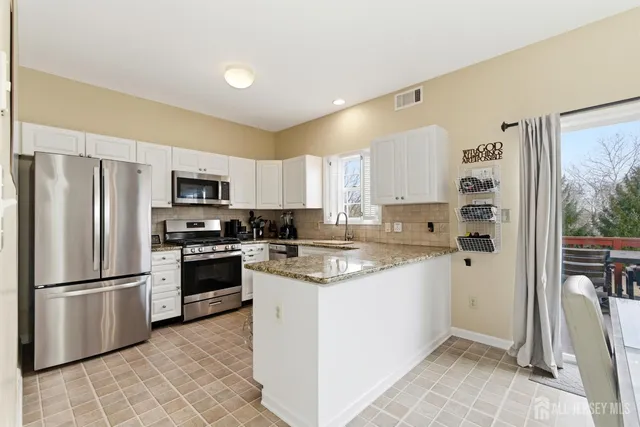 a kitchen with stainless steel appliances granite countertop a refrigerator sink and stove