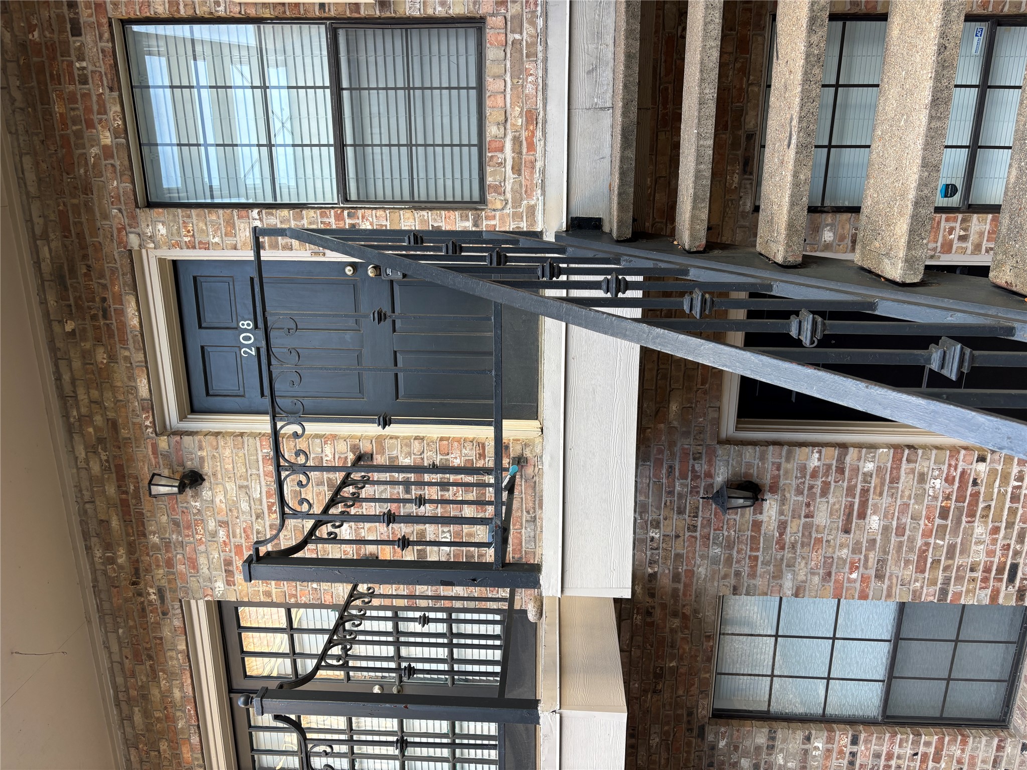 2801 Rio Grande Street, Unit 208 Austin, TX 78705 - Photo 1 of 8 A classic brick exterior presents a welcoming entrance with wrought iron railings and concrete steps.