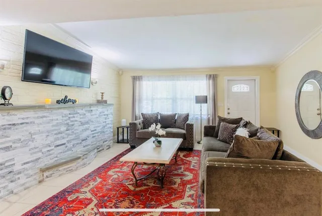 a kitchen with granite countertop a sink a stove top oven and cabinetry
