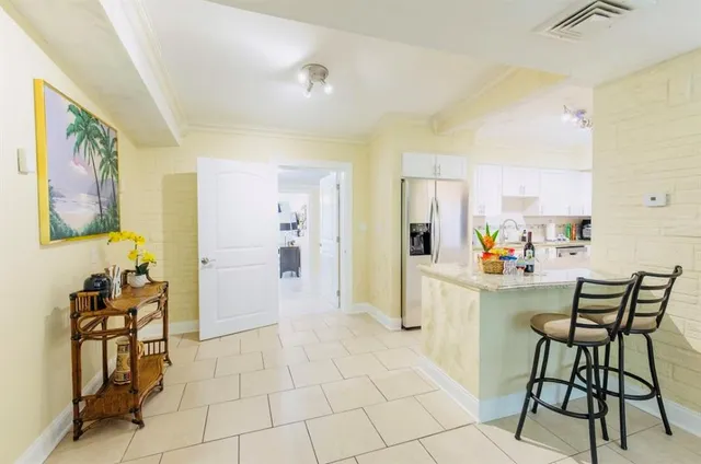 a kitchen with stainless steel appliances granite countertop a stove top oven a sink a dining table and chairs with wooden floor