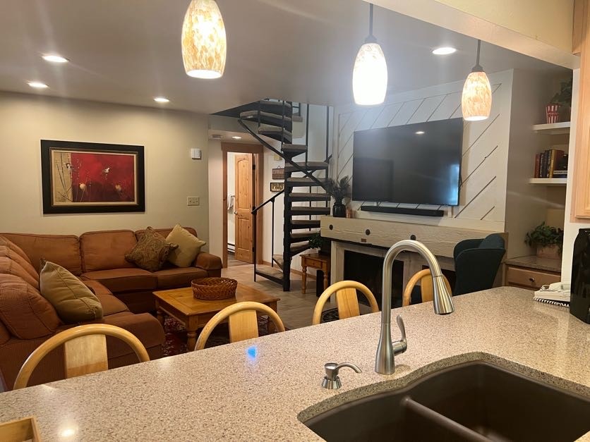 1937 Soda Ridge Road, Unit 1122 Keystone, CO 80435 - Photo 15 of 39 a blue kitchen with stainless steel appliances a sink a stove a microwave a dining table and chairs with wooden floor