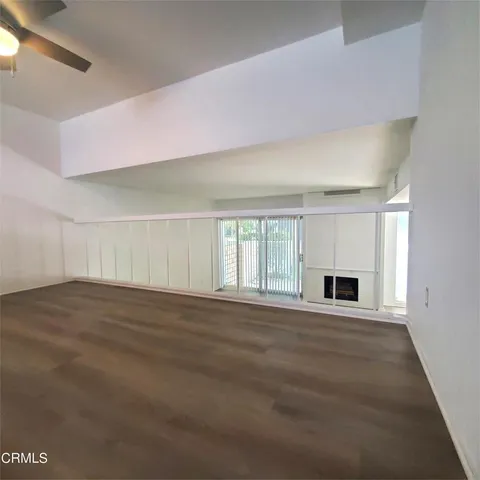 a view of empty room with wooden floor and fireplace