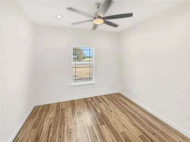 an empty room with a window and a ceiling fan