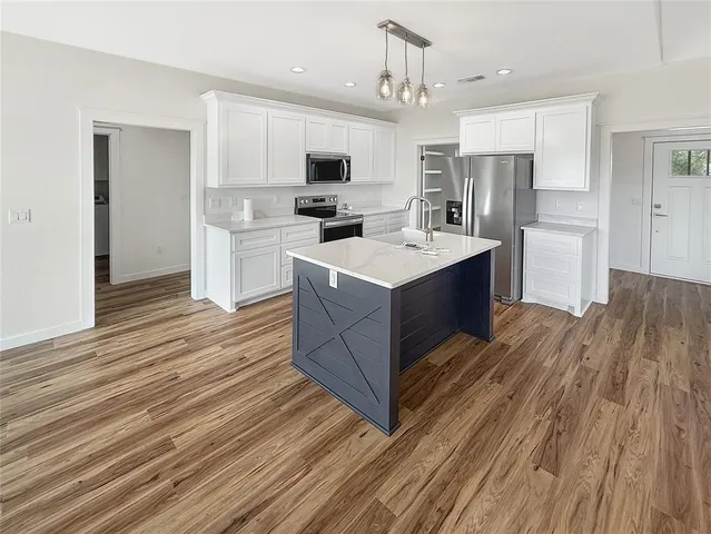 a kitchen with stainless steel appliances a stove top oven a sink dishwasher and a refrigerator