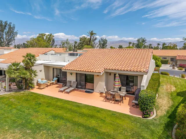 a view of a patio with table and chairs under an umbrella