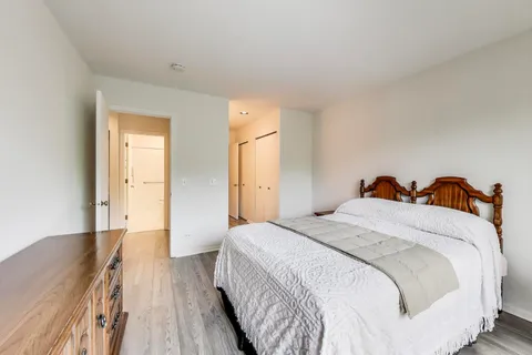 a spacious bedroom with a bed and wooden floor