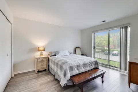 a bedroom with a bed and a lamp next to a window