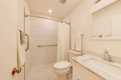 a bathroom with a granite countertop sink toilet and shower