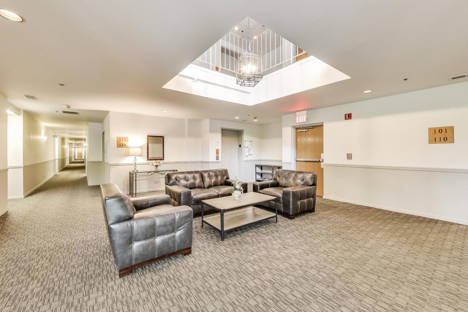 805 Leicester Road, Unit B105 Elk Grove Village, IL 60007 - Photo 4 of 37 a living room with furniture and white walls