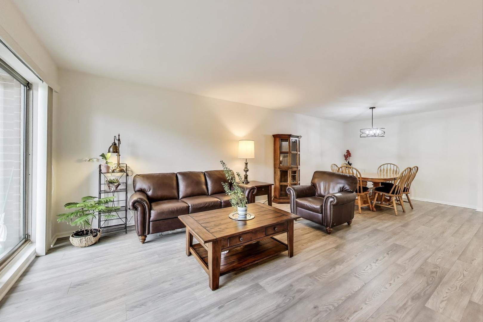 805 Leicester Road, Unit B105 Elk Grove Village, IL 60007 - Photo 6 of 37 a living room with furniture a rug and a lamp