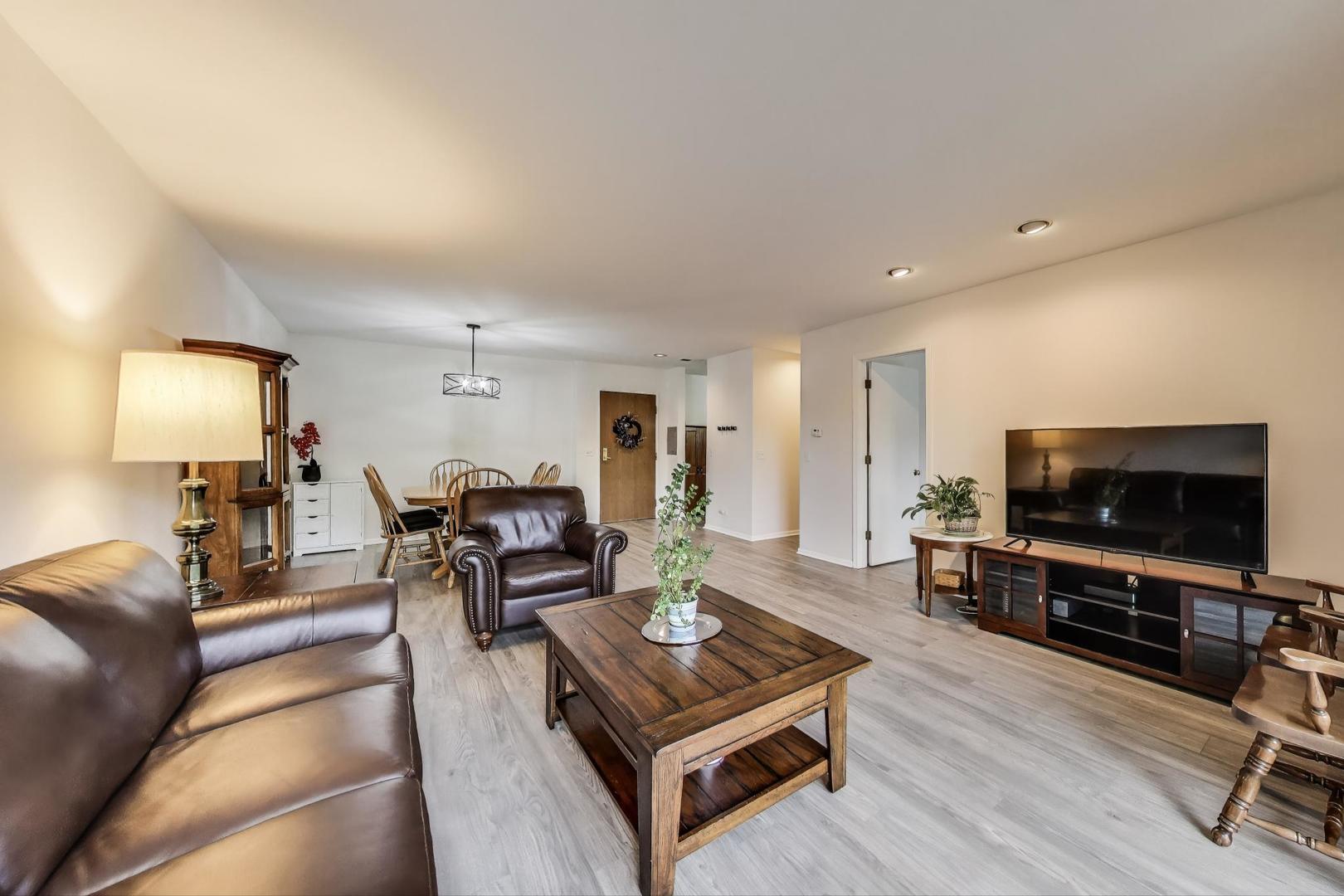 805 Leicester Road, Unit B105 Elk Grove Village, IL 60007 - Photo 7 of 37 a living room with furniture and a flat screen tv