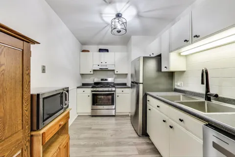 a kitchen with stainless steel appliances a sink stove and refrigerator