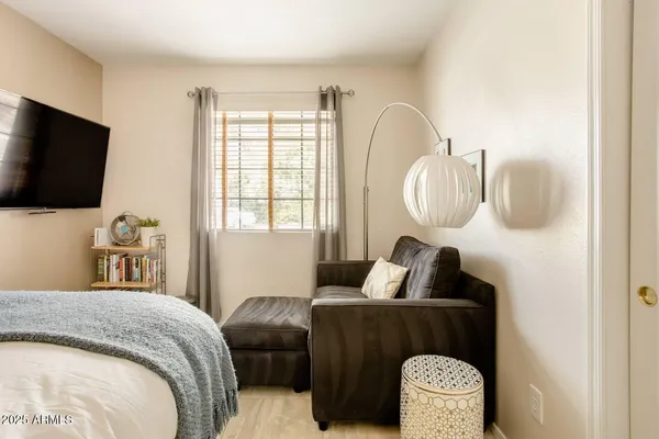 a bedroom with bed and a flat tv screen on dresser