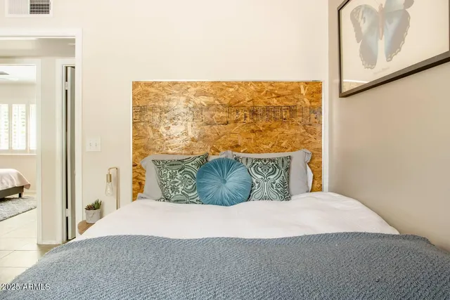 a large bed sitting in a bedroom next to a window