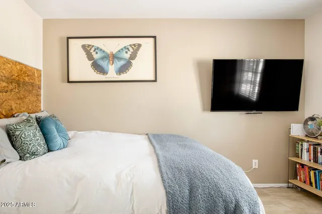 a bedroom with a bed and a flat screen tv