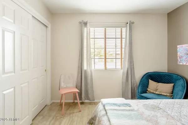 a bedroom with a bed chair and a window