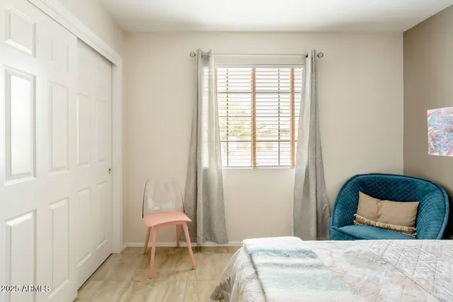 a bedroom with a bed chair and a window