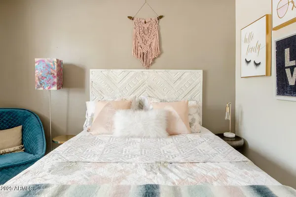a bedroom with a bed and painting on the wall