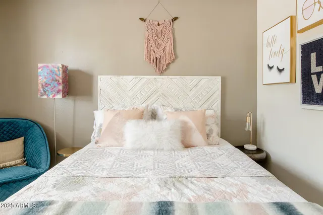 a bedroom with a bed and painting on the wall