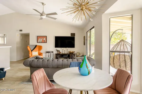 a living room with furniture a flat screen tv and a large window