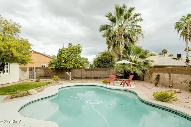 a swimming pool with outdoor seating and yard