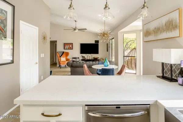 a living room with stainless steel appliances kitchen island granite countertop furniture and a fireplace