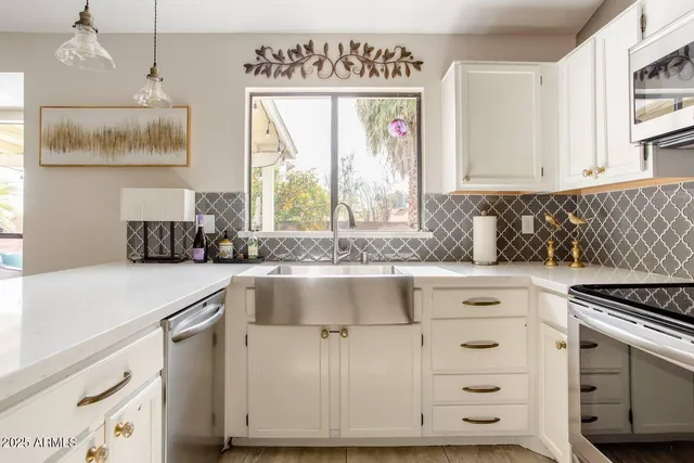 a kitchen with granite countertop a sink window and cabinets