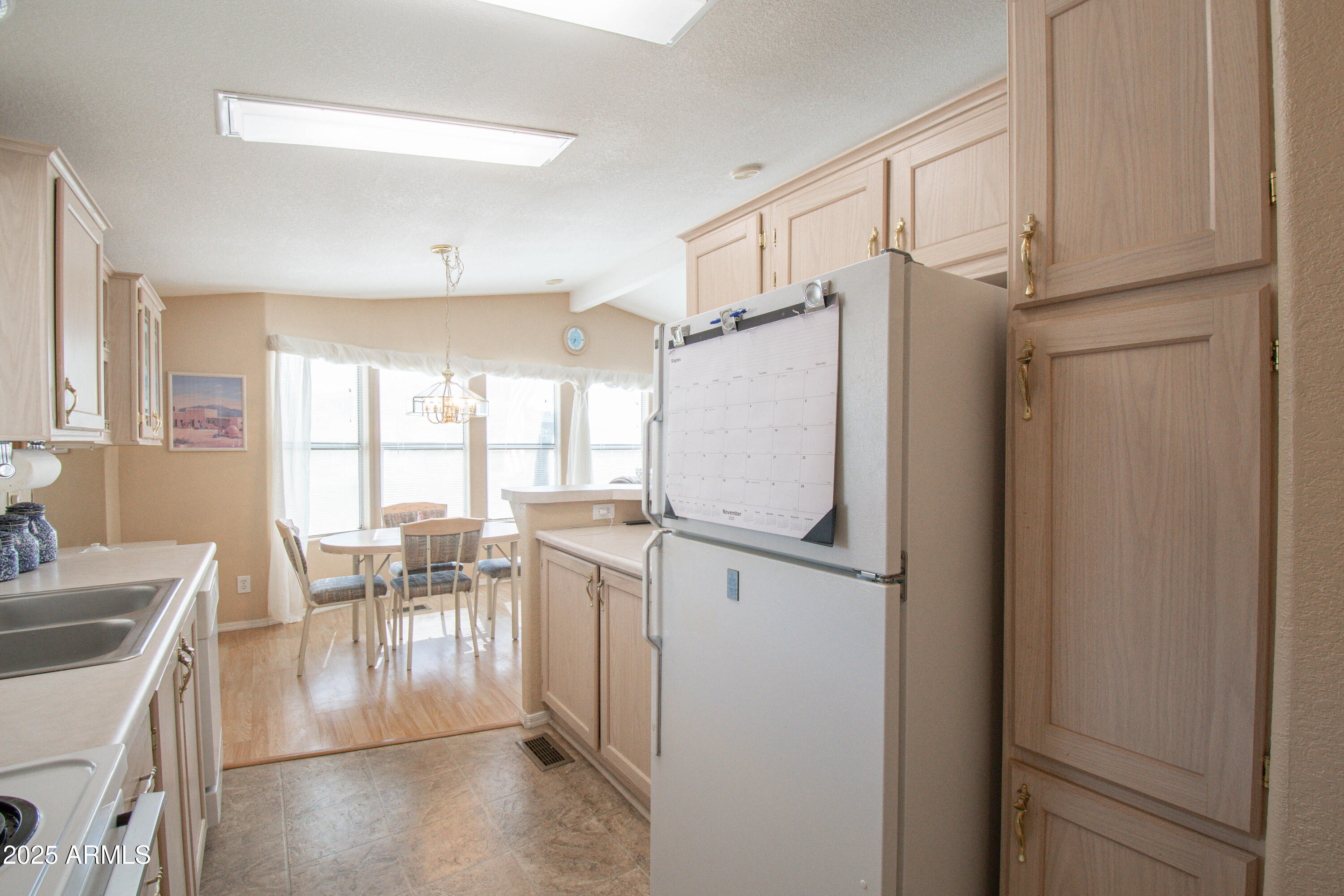 5735 East McDowell Road, Unit 410 Mesa, AZ 85215 - Photo 11 of 45 a kitchen with a refrigerator a table and chairs