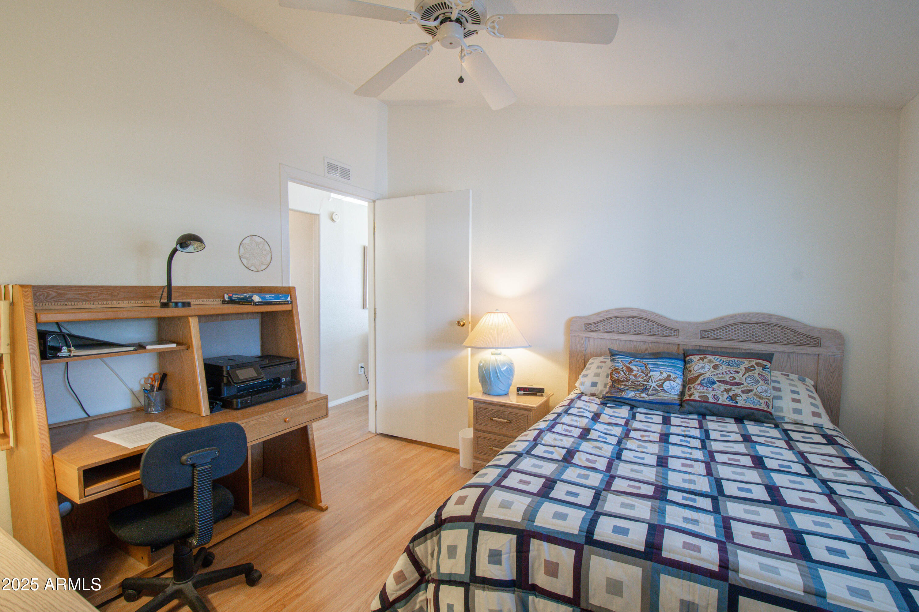 5735 East McDowell Road, Unit 410 Mesa, AZ 85215 - Photo 17 of 45 a bedroom with a bed and a table with wooden floor