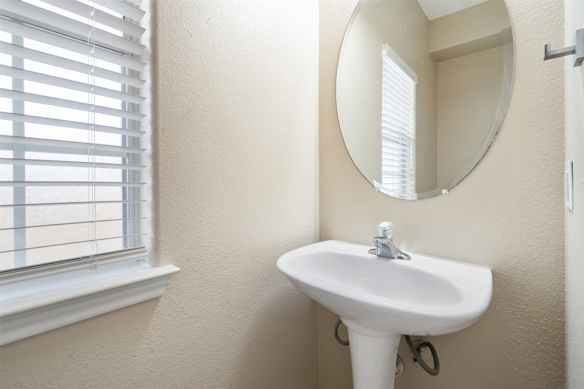 5909 Signal Point Austin, TX 78724 - Photo 12 of 32 a bathroom with a sink a mirror and a window