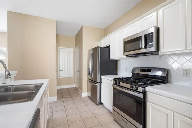 a kitchen with stainless steel appliances a stove a microwave and a sink
