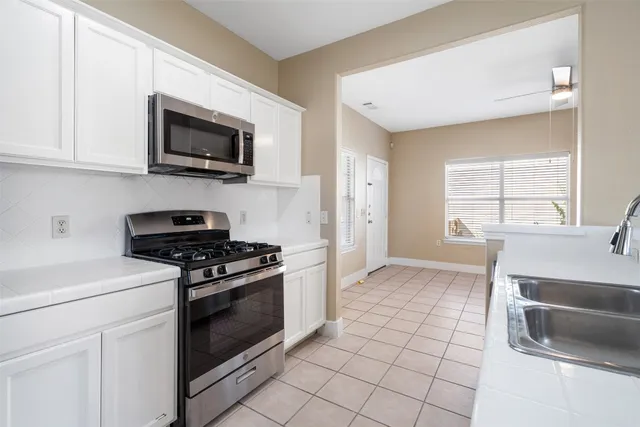 a kitchen with stainless steel appliances a stove a microwave and white cabinets