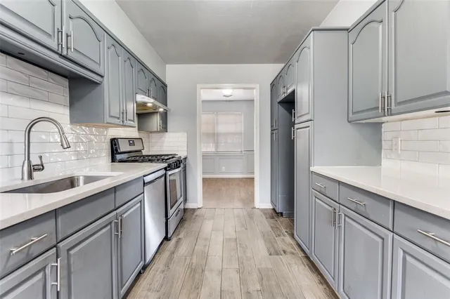 a view of a kitchen with cabinets and wooden floor