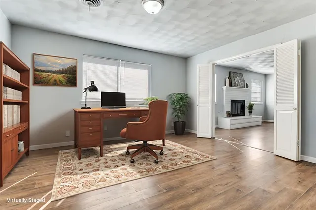 a view of a workspace with furniture and a window